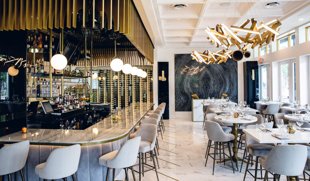 A well-lit dining room interior with plush chairs and tables, plus a bar