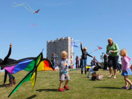 A child tries to get his kite in the air as others around him fly theirs