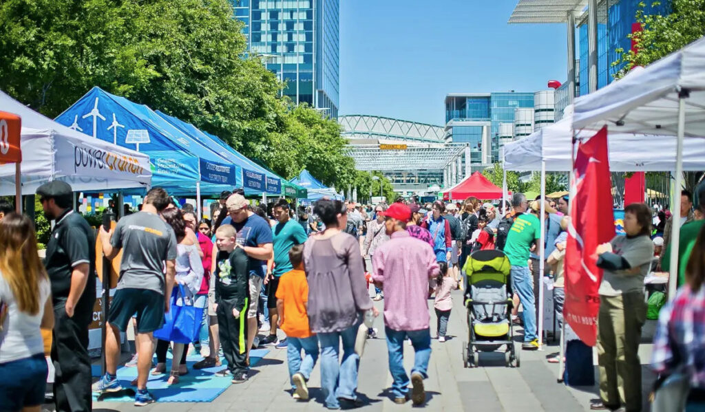 A bustling market scene with people moving past booths