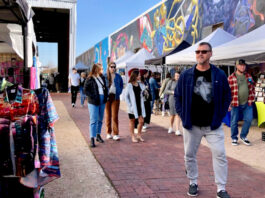 Groups of people walking between market stalls