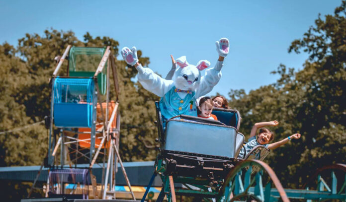 A roller coaster with children and the Easter Bunny riding