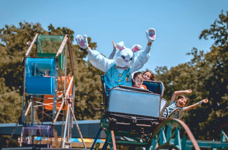 A roller coaster with children and the Easter Bunny riding
