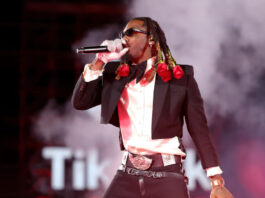 Rapper Offset performing on stage with roses in his hair