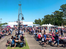 Crowds gather around tables and stroll by booths of barbecue vendors