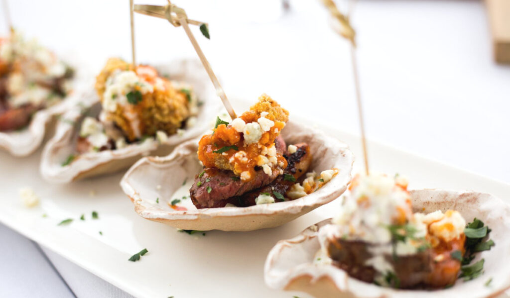 Oyster and slab bacon stacked on a half shell