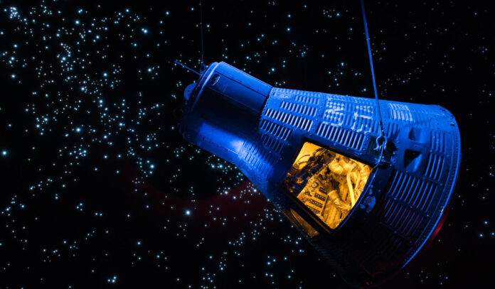 A exhibit display of a Gemini capsule floating in space