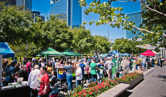 A bustling market scene with people moving past booths