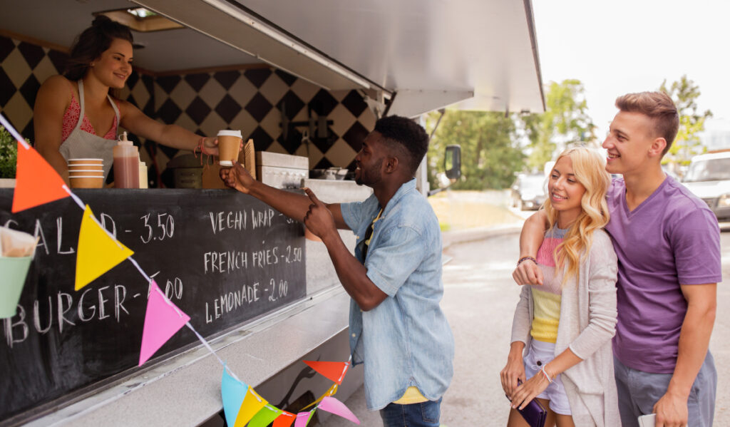 Smiling people lined up at a food truck