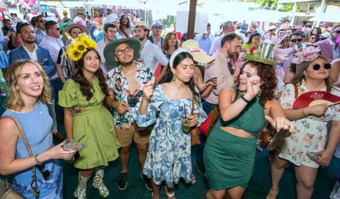 Onlookers watch the Kentucky Derby on an outdoor screen