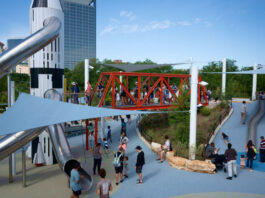 A tall Rocket slide on a playground with other play structures