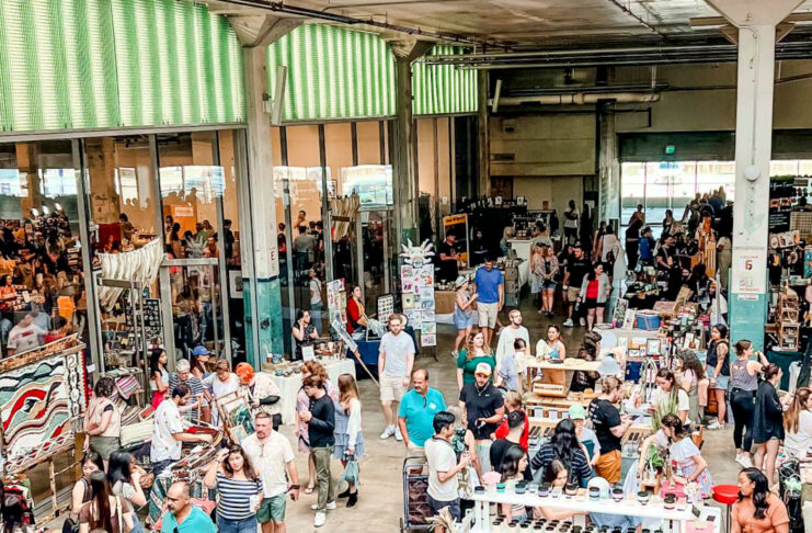 A view of a bustling marketplace with booths and people walking through