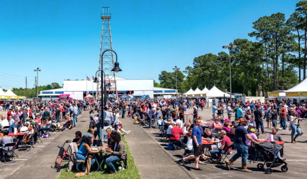 Crowds gather around tables and stroll by booths of barbecue vendors