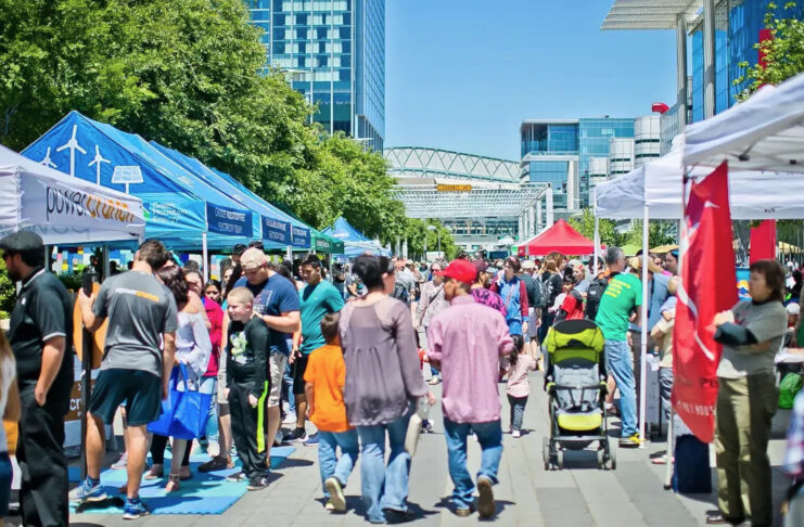 A bustling market scene with people moving past booths