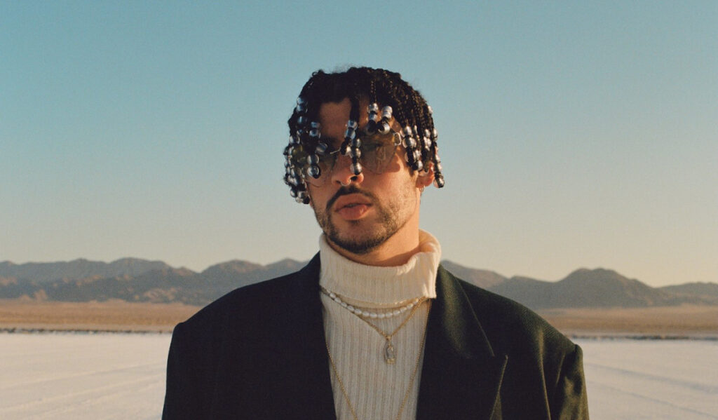 A close up of Bad Bunny's face with a desert background