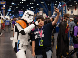A child poses with a Star Wars stormtrooper for a selfie