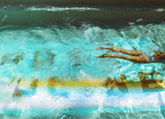 Take a dip with 18 day passes to hotel & resort pools around Greater Houston A woman swimming through a pool with a wake behind her