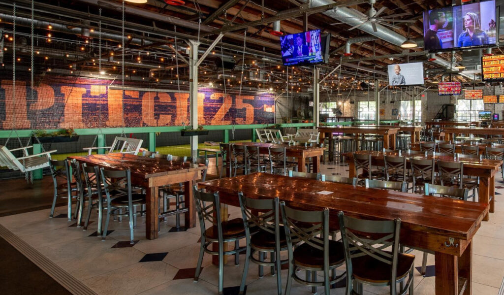 Interior of field 25 with empty tables, televisions and indoor soccer field