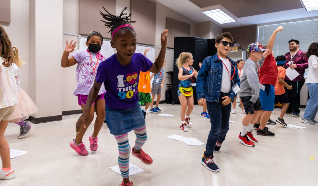 Several kids in mid-dance during a class session