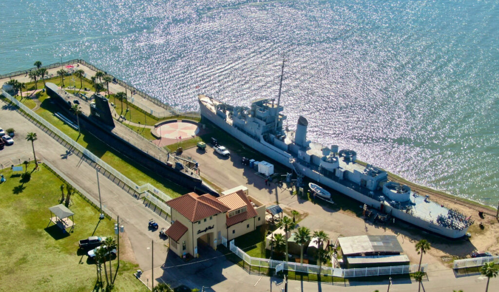 An aerial view of a battleship and submarine stationed at Seawolf Park