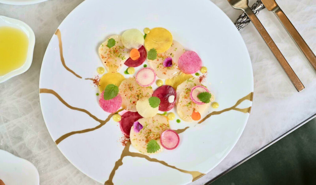 Overhead view of a plate with round slices artfully arranged on a plate in yellow, pink and red colors