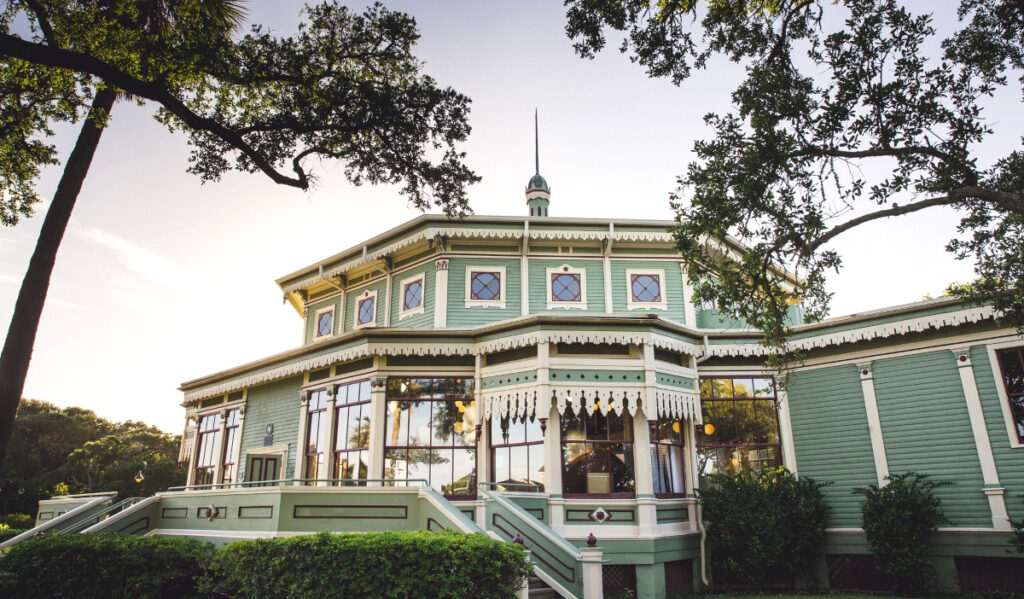 The exterior of a green Victorian-era building in Galveston