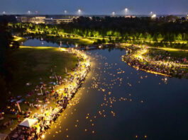 An aerial view of lanterns emerging onto a body of water