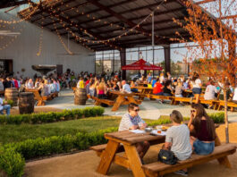 A covered outdoor patio garden with people sitting at tables