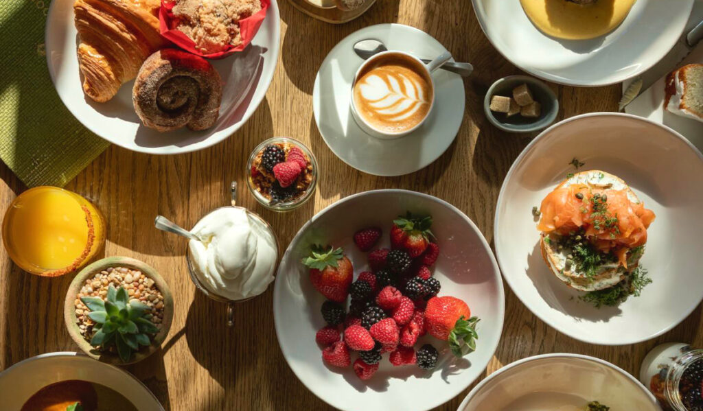 An overhead view of a brunch spread with fruit, coffee and pastries