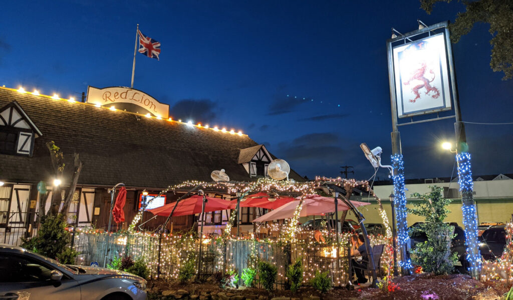 Exterior of Red Lion Pub at night, wrapped in lights