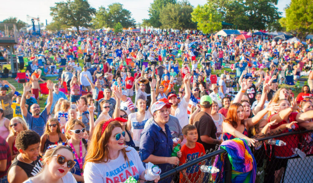 A field full of festival goers watching concerts