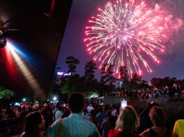 A crowd watches fireworks from Miller Outdoor Theatre