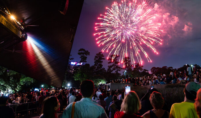 A crowd watches fireworks from Miller Outdoor Theatre