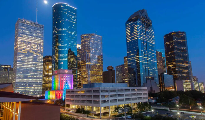A Downtown Houston skyline with rainbow colors projected on City Hall