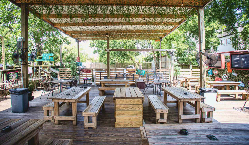 An empty covered outdoor patio with wooden furniture