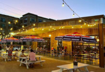 Houston Nightlife: The Best Bars in Arts District Houston An outdoor bar patio at sunset with people sitting at table under a string of lights