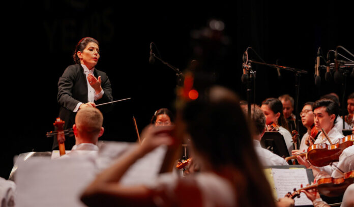 A conductor leads members of an orchestra