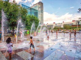 Kids playing on a splash pad with jets of water