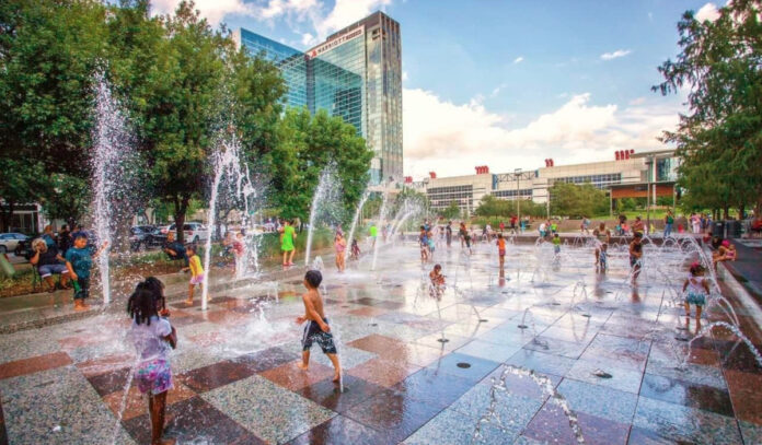 Kids playing on a splash pad with jets of water