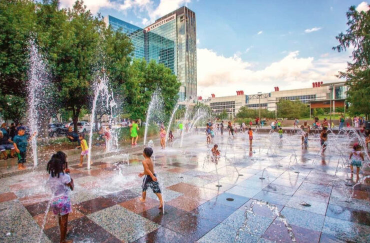 Kids playing on a splash pad with jets of water