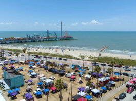 An aerial view of a marketplace on the shores of Galveston with an amusement park in the background