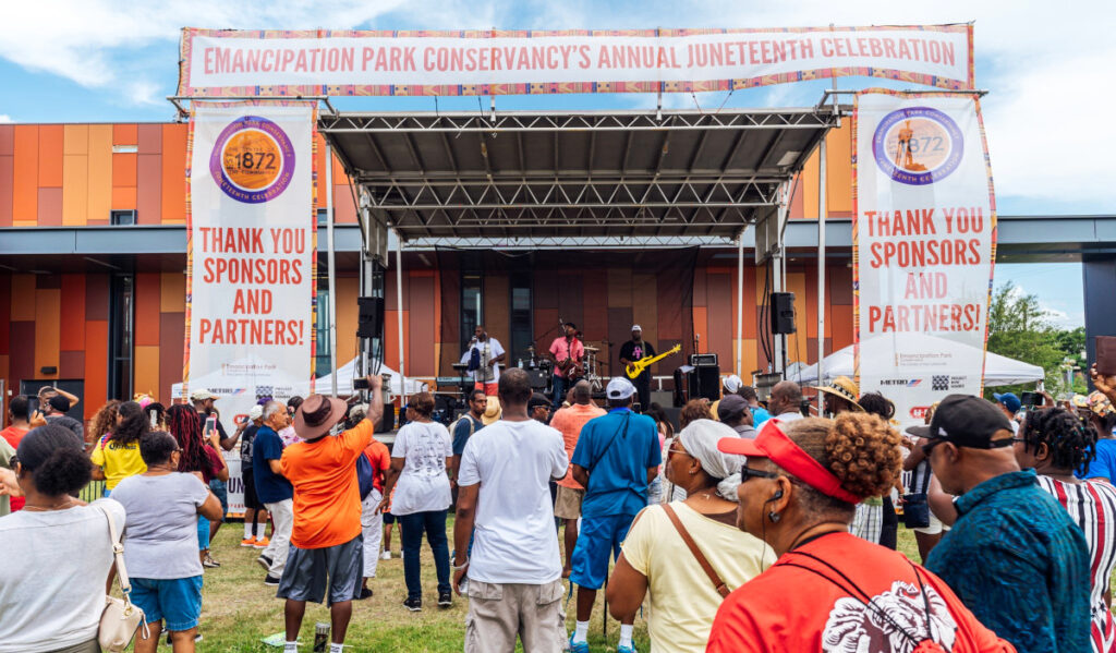 An outdoor concert scene with crowds watching musicians on stage