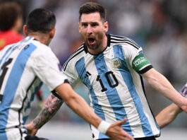 Lionel Messi with his arms outstretched celebrating a goal