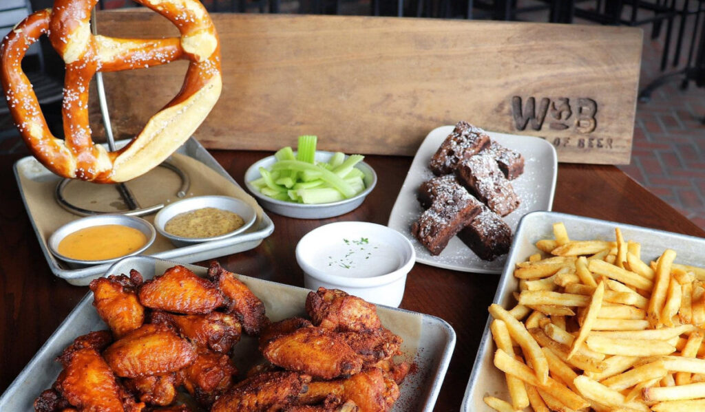 An assortment of appetizers; wings, pretzel, fries and more