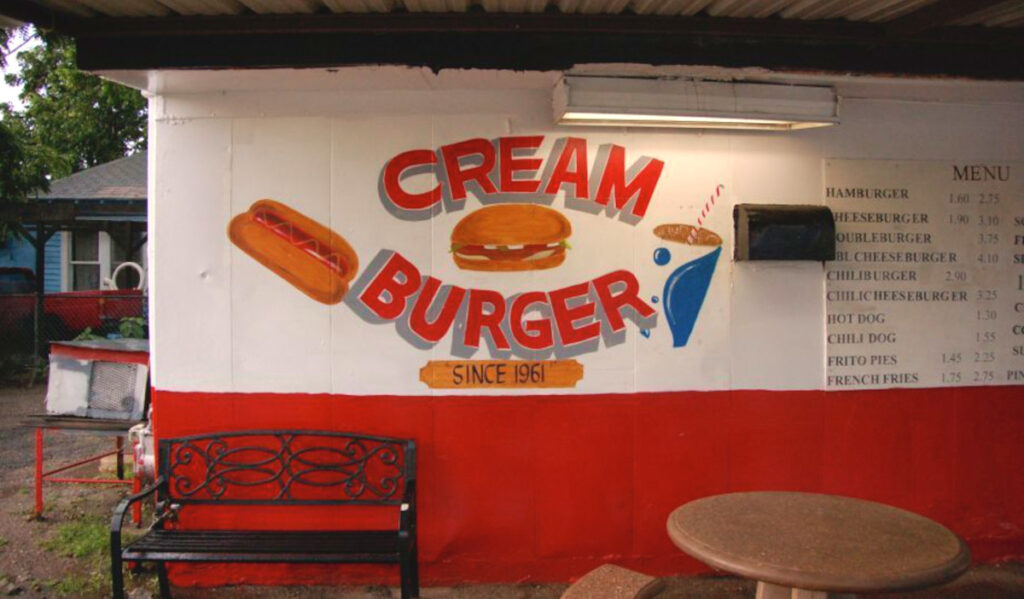 A painted mural that says "Cream Burger" with a hot dog, burger and drink