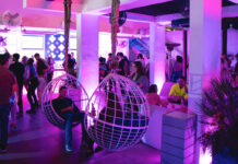 Houston Nightlife: The Best Bars in Midtown A bar interior lit in purple with two people sitting in suspended swings