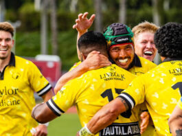 Members of the SaberCats rugby team smile and embrace