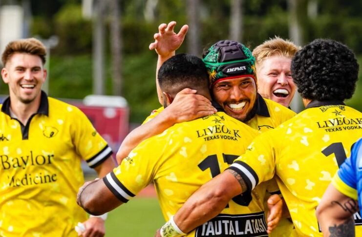 Members of the SaberCats rugby team smile and embrace