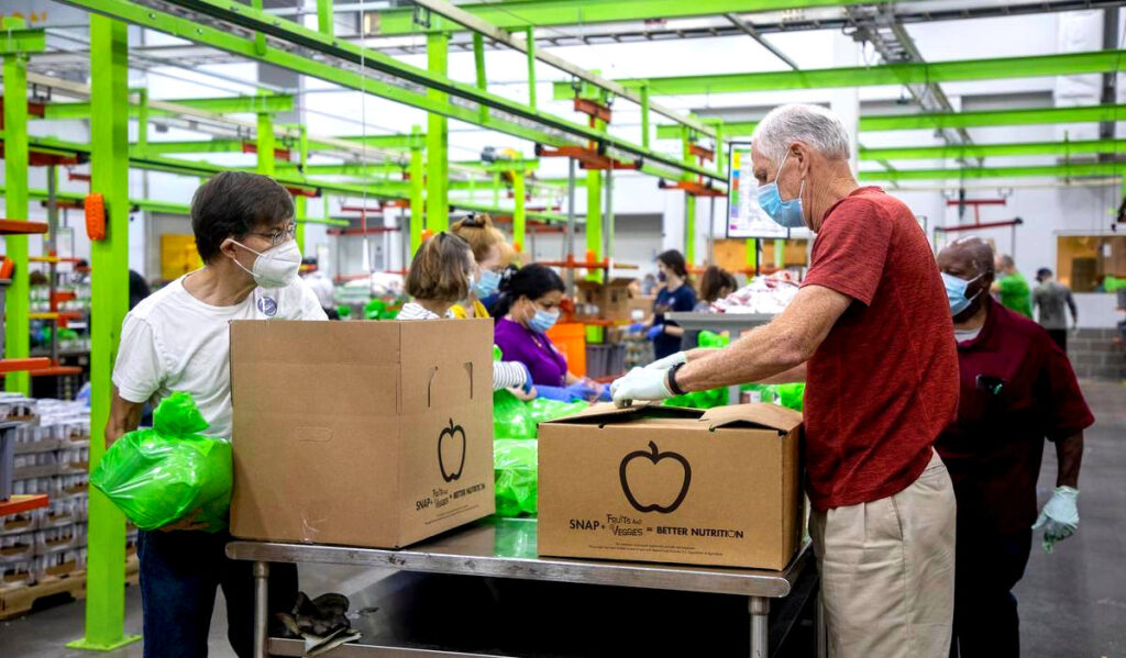 People packing boxes with food at a warehouse