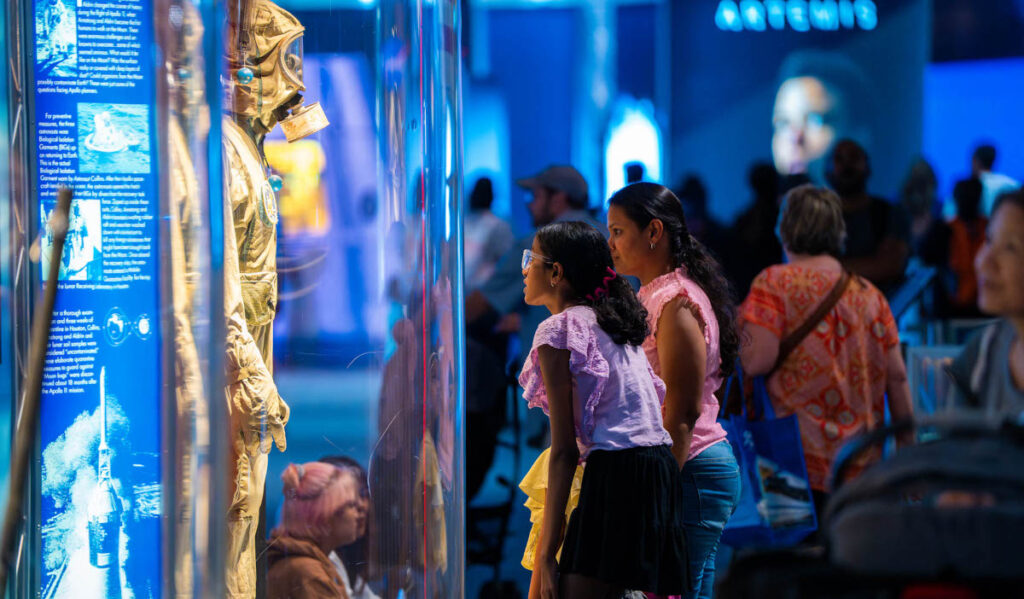 Two people looking at an exhibition with a mannequin in a jumpsuit