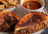 Where to Brunch in Sugar Land A grilled sandwich cut in halves on a plate with fries and a sauce dip